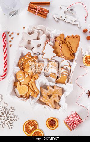 Vue de dessus d'un cadeau de noël déballé avec bonbons sur une surface texturée blanche, gros plan.Concept de fête de Noël Banque D'Images