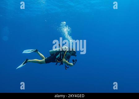 Plongée sous-marine explorant le récif Gota Abu Ramada sur 30 septembre 2022 à Hurghada, Mer Rouge, Egypte. Gota Abu Ramada est un récif ovale de taille moyenne entouré d'un fond marin plat et peu profond, situé à environ 1 heures en bateau, au sud de Hurghada. C'est l'un des sites de plongée les plus populaires de la région. Hurghada, et il est également appelé l'Aquarium, en raison de la variété et du grand nombre d'espèces de poissons. La profondeur maximale de ce site de plongée est d'environ 15 mètres. Ici, à Gota Abu Ramada, vous pouvez voir et vivre des moments merveilleux. C'est probablement le point le plus éloigné de votre plongée si vous commencez votre di Banque D'Images