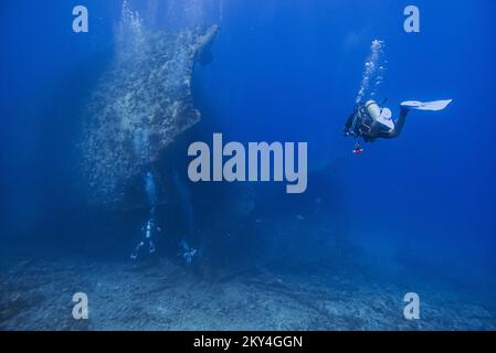 Plongée sous-marine explorant l'intérieur d'une épave submergée de Giannis D sur 30 septembre 2022 à Hurghada, Mer Rouge, Egypte. En avril 1983, Giannis D a été chargé de bois d'œuvre à Rijeka, en Croatie, destiné à l'Arabie saoudite et au Yémen. Le navire traverse la Méditerranée et traverse le canal de Suez. Le 19 avril 1983, il s'approchait à pleine vitesse du détroit de Gobal lorsqu'il a été vu soudainement dévier et s'écraser lourdement dans le coin nord-ouest de la crête Sha'ab Abu Nuhas. L'équipage a abandonné le navire et a été secouru en toute sécurité. L'épave submergée de Giannis D est située à une profondeur de 4 à 2 Banque D'Images