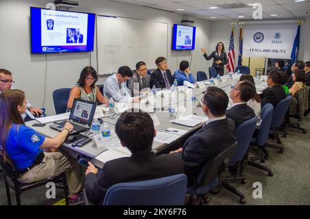 Queens (N.Y.), 30 mai 2013 la FEMA a souhaité la bienvenue aux représentants du gouvernement, de la République de Singapour, de la République de Corée et du Royaume-Uni, ainsi qu'aux membres de la Brookings institution, au Bureau mixte de terrain de New York (JFO) pour les informer des procédures de reprise après sinistre de l'ouragan Sandy. Jessica Steinbeck, coordonnatrice internationale des visiteurs, présente un aperçu de la FEMA. K.C.WILSEY/FEMA. New York ouragan Sandy. Photographies relatives aux programmes, aux activités et aux fonctionnaires de gestion des catastrophes et des situations d'urgence Banque D'Images