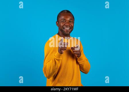Charismatique beau homme noir pointant vers l'appareil photo Banque D'Images