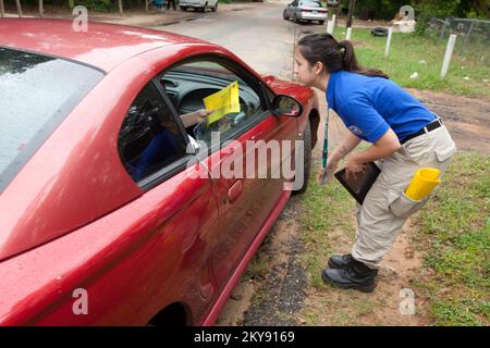 Pensacola, Floride, membre du corps de la FEMA de 14 mai 2014, Kylie Miller distribue des informations sur les catastrophes dans le quartier de Benrant, à Pensacola. La région a été frappée par une pluie torrentielle à la suite d'une paire d'orages qui ont déclenché d'importantes inondations éclair le long de parties du Panhandle de Floride. Andrea Booher/FEMA. Floride tempêtes sévères, tornades, vents en ligne droite et inondations. Photographies relatives aux programmes, aux activités et aux fonctionnaires de gestion des catastrophes et des situations d'urgence Banque D'Images