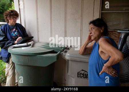 Pensacola, Floride, 14 mai 2014 membre de l'équipe d'assistance aux survivants de catastrophes Kay Kimmler enregistre la survivante de catastrophes,Theresa Rincon pour l'aide en cas de catastrophe dans le port de sa maison détruite dans le quartier de Pensacola de Brant, en Floride. Andrea Booher/FEMA. Floride tempêtes sévères, tornades, vents en ligne droite et inondations. Photographies relatives aux programmes, aux activités et aux fonctionnaires de gestion des catastrophes et des situations d'urgence Banque D'Images