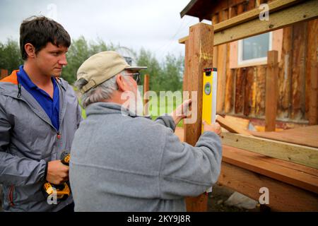 Circle, AK, 15 juillet 2014 le volontaire Mennonite Disaster Services Mark Stulnbawa (L) prépare son exercice tandis que le directeur de projet Harold Miller (R) place le poste sur une rampe accessible aux handicapés pour une maison de survivants d'une catastrophe qui a été endommagée par une grave inondation en mai 2013. Après la suspension des mesures de rétablissement à la fin de 2013 en raison des conditions météorologiques hivernales extrêmes, la FEMA, l'État de l'Alaska et les volontaires sont de retour travailler pour achever la reconstruction et la réparation des survivants de catastrophes qui sont admissibles à l'aide individuelle. Adam DuBrowa/FEMA. Inondations en Alaska. Photographies relatives à Banque D'Images