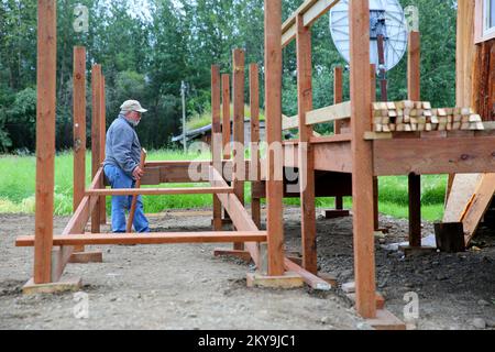 Circle, AK, 15 juillet 2014 le directeur du projet des services de catastrophe mennonite Harold Miller reconstruit une rampe accessible à l'hanicap pour une maison de survivants de catastrophe qui a été endommagée par une grave inondation en mai 2013. Après la suspension des mesures de rétablissement à la fin de 2013 en raison des conditions météorologiques hivernales extrêmes, la FEMA, l'État de l'Alaska et les volontaires sont de retour travailler pour achever la reconstruction et la réparation des survivants de catastrophes qui sont admissibles à l'aide individuelle. Adam DuBrowa/FEMA. Inondations en Alaska. Photographies relatives aux programmes, aux activités et aux services de gestion des catastrophes et des urgences Banque D'Images