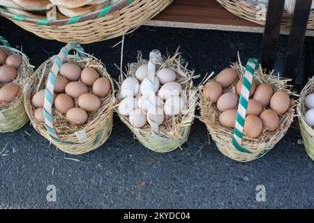 Oeufs frais de la ferme organique dans le panier de paille Banque D'Images