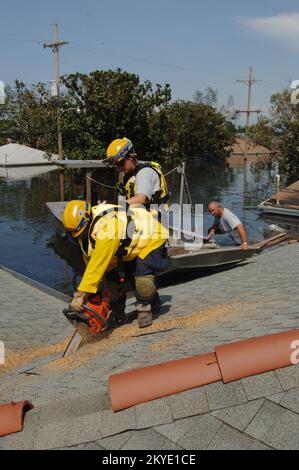 Ouragan Katrina, la Nouvelle-Orléans, la, 08/31/05 -- une équipe de recherche et de sauvetage urbains (US&R) s'est emparée d'un toit avec une tronçonneuse pour qu'il puisse inspecter le grenier de cette maison située dans l'un des quartiers inondés de la Nouvelle-Orléans. La Nouvelle-Orléans est en cours d'évacuation et les équipes US&R sont à la recherche de survivants et de victimes de l'ouragan Katrina. Banque D'Images