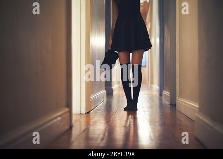 Sur son chemin. Image rognée d'une jeune femme qui s'est promenée dans le couloir de sa maison. Banque D'Images