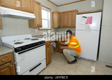 Ouragan Katrina, Purvis, MS, 13 décembre 2005 - Un employé de la FEMA inspecte la plomberie dans la cuisine d'une maison mobile de la FEMA avant qu'elle ne soit libérée à sa famille désignée. Toutes les remorques et les maisons mobiles sont inspectées avant de quitter la zone de transit de Purvis, MS. Patsy Lynch/FEMA Banque D'Images