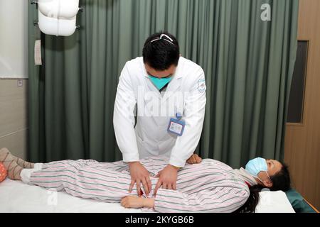 CHONGQING, CHINE - 1 DÉCEMBRE 2022 - Un médecin chinois traditionnel utilise un massage thérapeutique chinois traditionnel pour donner une femme post-partum Banque D'Images