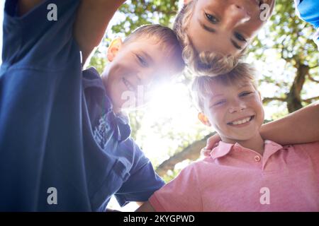 Il suffit de se tromper en attendant de se produire. Trois frères se tenant ensemble tout en jouant à l'extérieur sous le soleil éclatant. Banque D'Images