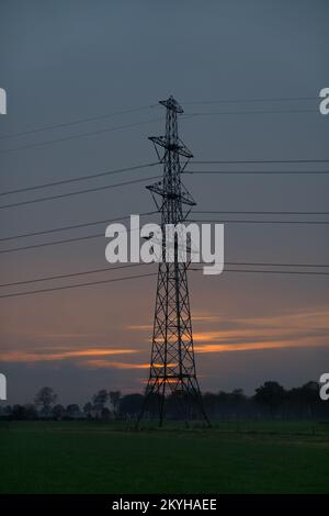 Silhouette de pylône électrique avec fils contre le ciel de coucher de soleil Banque D'Images