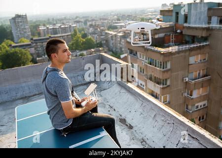 Jeune technicien homme volant UAV drone avec télécommande dans la ville Banque D'Images