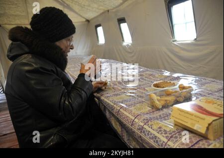 Non exclusif: LADYZHYN, UKRAINE - 29 NOVEMBRE 2022 - Une femme âgée mange un biscuit et boit du thé à un point d'invincibilité comme une émergente militaire Banque D'Images