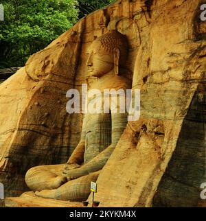 Galviharaya, Utharamaya, Polonnaruwa est célèbre pour ses trois statues de Bouddha, sculptées dans un rocher de gneiss de granit. Trois portraits de Bouddha, assis, incliné et debout sont vivants comme. Les sculptures smartness peuvent être vues à travers la douce, translucide sivura. Les flottes de la sivura comme les vagues de la mer. Polonnaruwa, Sri Lanka. Banque D'Images