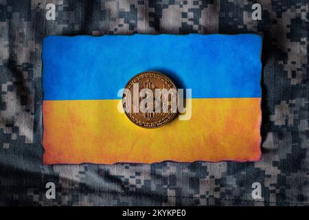 Jeton de Bitcoin sur le drapeau ukrainien, sombre grunge militaire camouflage arrière-plan abstrait, Banque D'Images