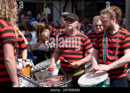 DakaDoum le groupe de percussions afro/brésilienne se présente au centre-ville de Penzance sur la procession colorée de la journée Mazey en Cornouailles, en Angleterre, au Royaume-Uni. Banque D'Images
