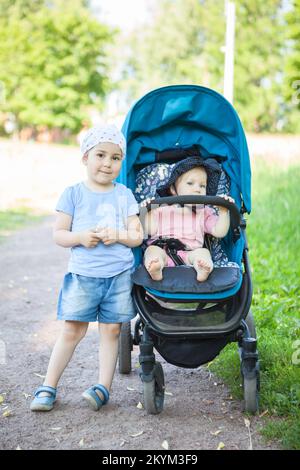 Enfants de race blanche de différents âges lors d'une promenade dans le parc Banque D'Images