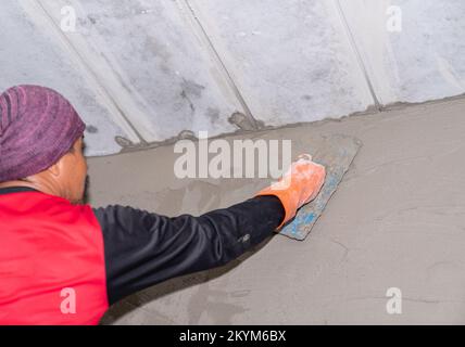 Un employé plâtrage à l'intérieur du mur sur le chantier. Banque D'Images