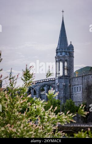 Vue sur l'une des spire de la basilique notre-Dame datant du 19th siècle à Lourdes, dans les Pyrénées françaises Banque D'Images