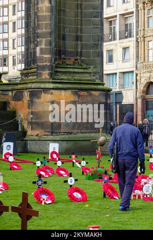 Des gens parmi les couronnes au jardin du souvenir, pour honorer les morts et se souvenir des vivants, Princes Street Gardens, Édimbourg, Écosse, Royaume-Uni. Banque D'Images