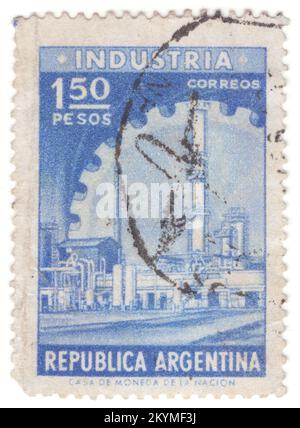 ARGENTINE - 1958: Timbre-poste d'outremer de 1,50 pesos représentant l'industrie allégorie de l'Argentine — bâtiments d'une usine chimique de raffinage de pétrole sur le fond d'une roue à engrenages géante. Bien intégrée dans l'agriculture Argentine, la moitié des exportations industrielles ont une origine rurale. Les principaux secteurs en volume étaient les suivants : transformation des aliments, boissons et produits du tabac; véhicules automobiles et pièces automobiles; textiles et cuir; produits de raffinage et biodiesel; produits chimiques et pharmaceutiques; acier, aluminium et fer; machines industrielles et agricoles; appareils électroménagers et meubles; plastiques et pneus, verre Banque D'Images