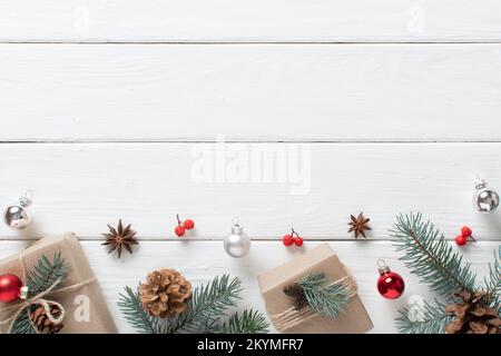 Cadeaux de Noël enveloppés de papier kraft et décorés de matériaux naturels sur une table en bois blanc. Noël zéro . Faites-le vous-même. Espace pour la copie Banque D'Images