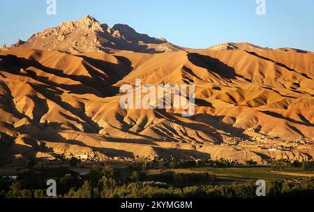 Bamyan (Bamiyan) dans le centre de l'Afghanistan. Une vue sur la vallée de Bamyan montrant des montagnes dorées éclairées par le soleil bas avec des ombres. Banque D'Images