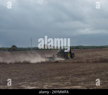 Odeceixe, Odemira, Portugal, 28 octobre 2021:tracteur labourage de terrain en automne, préparation de terrain avec cultivateur de semis. Jour nuageux Banque D'Images