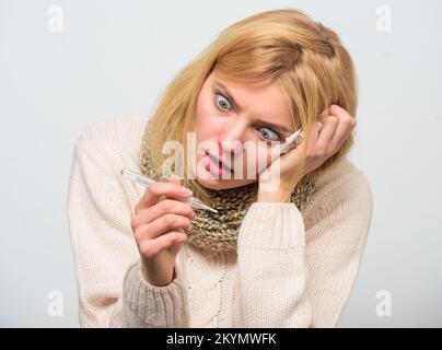 Une fille en foulard tient le thermomètre et le mouchoir de près. Mesurer la température. Remèdes contre la fièvre. Prenez la température et évaluez les symptômes. Température élevée Banque D'Images