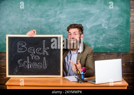 L'enseignant ou le directeur de l'école accueille avec inscription au tableau noir de retour à l'école. Bienvenue. L'enseignant accueille les nouveaux élèves pour entrer dans l'enseignement Banque D'Images