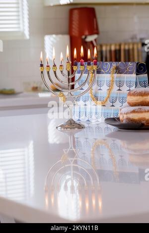 Le symbole juif de la fête Hanoukkah brille de mille feux sur fond flou de Hanoukkiah Menorah Banque D'Images
