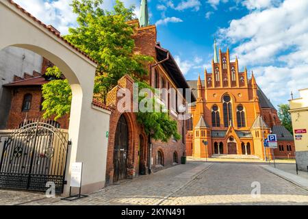 Vue sur la rue néo-gothique Église Catherine (Kościół św. Katarzyny W Toruniu) de la rue Szpitalna, Torun, Pologne Banque D'Images