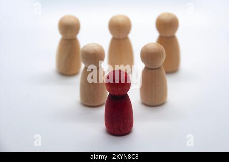 Figure rouge avant autre figure en bois avec fond blanc. Concept de leadership. Banque D'Images