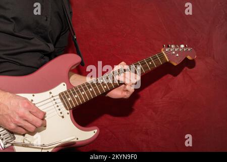 Vaduz, Liechtenstein, 11 janvier 2022 le musicien joue un Fender Stratocoaster USA 1995 dans la couleur de la brume bordeaux Banque D'Images