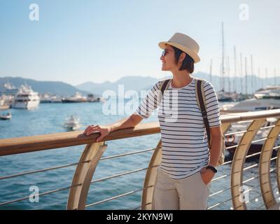 Marmaris est une station balnéaire sur la Riviera turque, également connue sous le nom de Côte Turquoise. Marmaris est l'endroit idéal pour la voile et la plongée. Femme asiatique avec chapeau marchant sur la jetée dans le port. Banque D'Images
