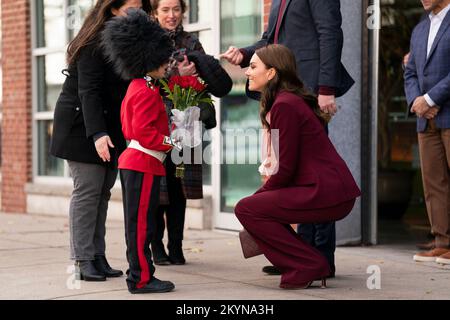 Le prince et la princesse de Galles sont présentés avec des fleurs par Henry Dynov-Teixeira, 8 ans, habillé comme un guardsman, lors d'une visite aux laboratoires Greentown à Somerville, pour en apprendre plus sur les innovations climatiques qui sont incubées à Boston. Date de la photo: Jeudi 1 décembre 2022. Banque D'Images