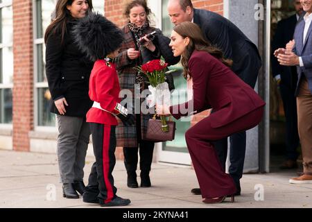 Le prince et la princesse de Galles sont présentés avec des fleurs par Henry Dynov-Teixeira, 8 ans, habillé comme un guardsman, lors d'une visite aux laboratoires Greentown à Somerville, pour en apprendre plus sur les innovations climatiques qui sont incubées à Boston. Date de la photo: Jeudi 1 décembre 2022. Banque D'Images