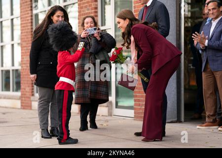 Le prince et la princesse de Galles sont présentés avec des fleurs par Henry Dynov-Teixeira, 8 ans, habillé comme un guardsman, lors d'une visite aux laboratoires Greentown à Somerville, pour en apprendre plus sur les innovations climatiques qui sont incubées à Boston. Date de la photo: Jeudi 1 décembre 2022. Banque D'Images