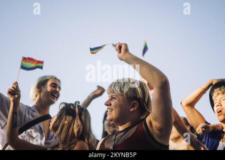 Bonne personne non binaire avec des amis qui profitent de la parade des droits LGBTQIA Banque D'Images