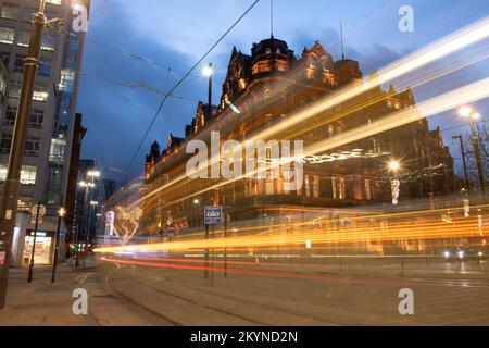 Des sentiers de lumière des trams et de la circulation en face de l'hôtel Midland sur la place Saint-Pierre dans le centre-ville de Manchester. Banque D'Images