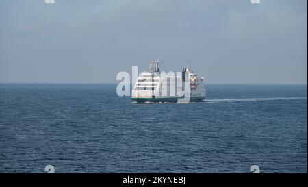 Grand ferry blanc vu de loin dans l'eau bleue. Vue de face avec espace de copie. Fehmarn, Allemagne - 27 novembre 2022. Banque D'Images