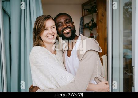 Heureux couple multiracial s'embrassant à la porte Banque D'Images