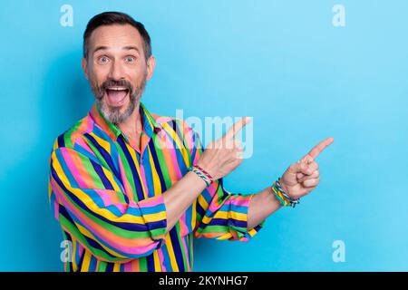 Portrait photo de l'homme ancien mature barbe grise bouche ouverte doigt direct espace vide stupéfait fou nouvelles de rupture isolées sur fond bleu couleur Banque D'Images