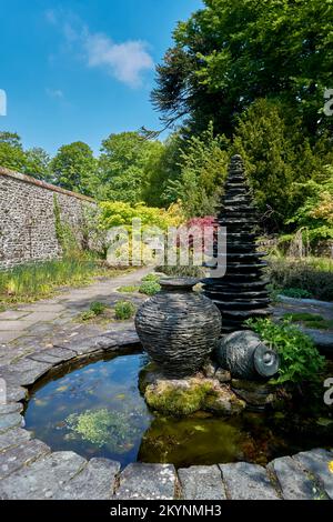 Ardoise et sculptures en pierre dans un plan d'eau aux jardins de Threave près du château Douglas à Dumfries et Galloway, en Écosse. Banque D'Images