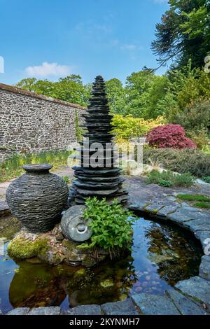 Ardoise et sculptures en pierre dans un plan d'eau aux jardins de Threave près du château Douglas à Dumfries et Galloway, en Écosse. Banque D'Images