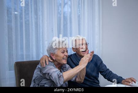 un couple marié âgé dans les bras de l'autre est fier de sourire. un homme célèbre son anniversaire de 80th ans, embrassant sa femme qui applaudit et smil Banque D'Images