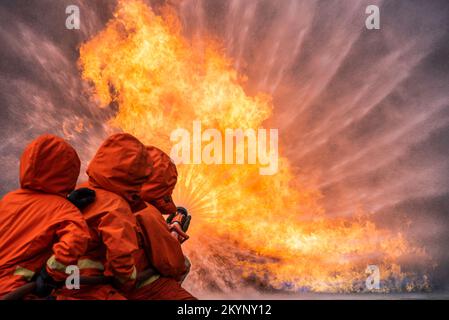 Pompier formation de sauvetage pour arrêter de brûler des flammes, pompier porter un casque et un uniforme de sécurité pour la protection brûler en utilisant le tuyau avec de l'eau chimique FO Banque D'Images