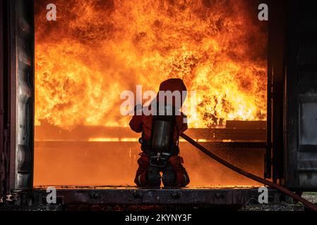 Pompier formation de sauvetage pour arrêter de brûler des flammes, pompier porter un casque et un uniforme de sécurité pour la protection brûler en utilisant le tuyau avec de l'eau chimique FO Banque D'Images