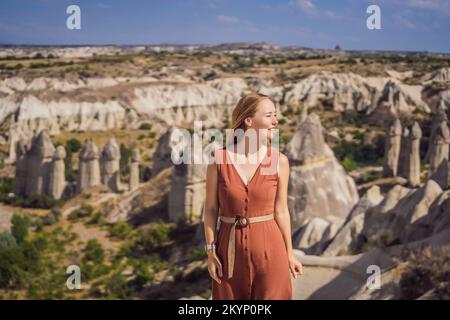 Jeune femme explorant la vallée avec des formations rocheuses et des grottes de fées près de Goreme en Cappadoce Turquie Banque D'Images